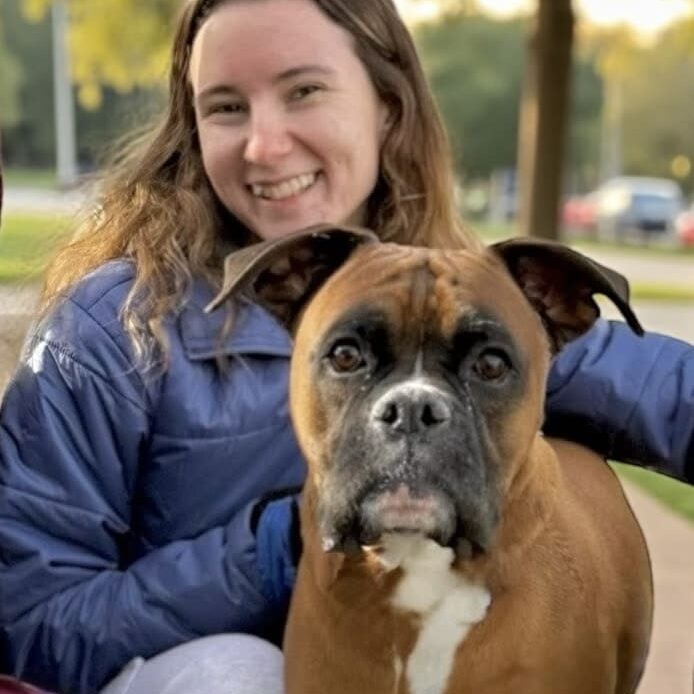 Smiling woman with brown Boxer dog
